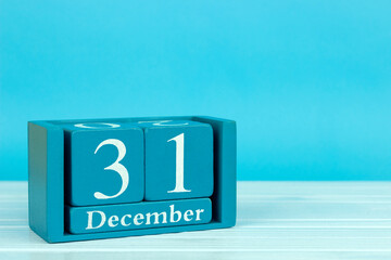 wooden calendar with the date of December 31 on a blue wooden background