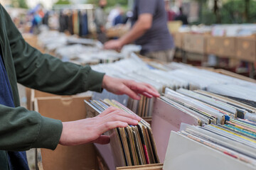 Selective focus at hand which pick and select second hand old fashion phonograph discs  in the...