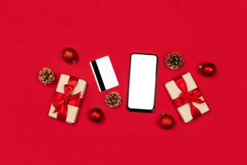 Smartphone mockup. Gifts, credit card, smartphone, fir cones, red decoration flat lay on red background top view, copy space. Onile christmas shopping concept. 2021 Happy new year, xmas holidays.