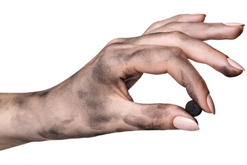 Activated carbon pill in a dirty female hand