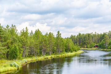 Obraz premium River that flowing through a forest with a log cabin