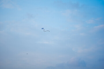 Fototapeta na wymiar Flying kite reaching high against the blue sky.jpg
