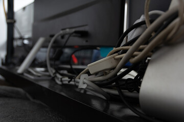 Lot of cables behind a desk of a home musician