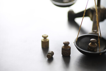 Tiny weights on vintage balance scales. Detail of Ancient old scale, Vintage old brass weight scale.