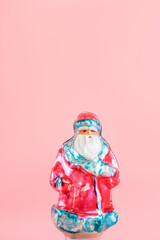 Old vintage Christmas toy - Santa Claus. Festive new year concept, pastel pink background. Minimalism. XX century, antiques.