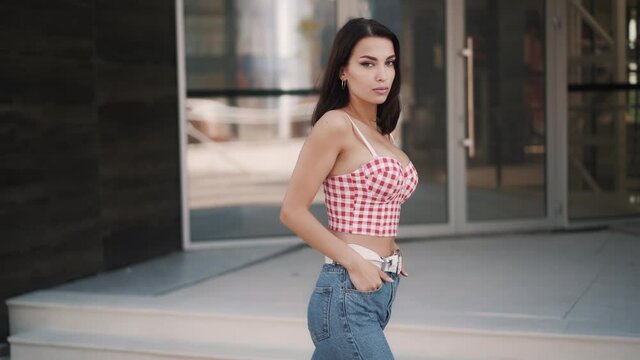 Cute young sexy caucasian brunette model walks down the stree