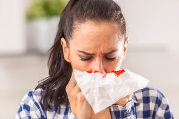 Woman clears her nose, unaware of bleeding that appeared on a tissue