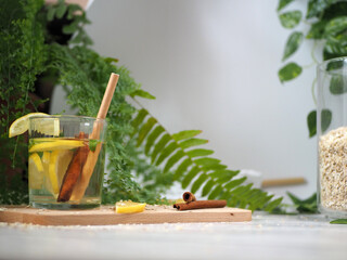 Cocktail on the table, drink with cinnamon stick on a wooden board. A fern sprig visible
- 392424119