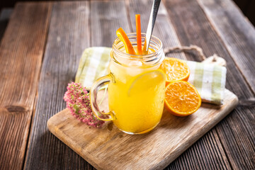 Lemonade drink with lemon slices, ice, orange juice in mason jars