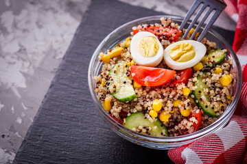 bowl of healthy quinoa with vegetables on a dark rustic background