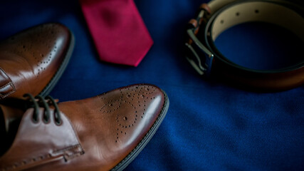 Close up of male wedding groom accessories set .Fashion style brown leather shoes and belt and tie blue marine suit