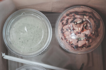 Iced chocolate and iced matcha green tea in takeaway or to go cup.