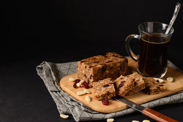 Homemade Toffee or sherbet, traditional Oriental sweet made from milk and sugar with nuts and dried cranberries. Dessert from Arabic or Turkish cuisine on wooden cutting board on black background