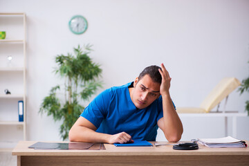 Young male doctor being extremely tired after night shift