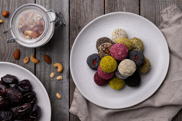 Raw energy bites balls prepared with natural ingredients on old rustic wooden background