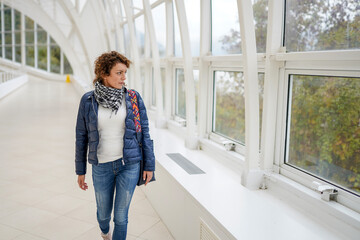 Young woman walking in lobby and looking through window