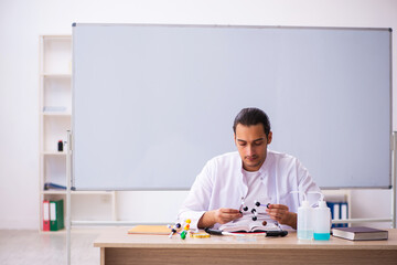 Young male chemistry teacher in the classroom