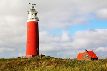 
West Frisian Islands in the Netherlands. Red lighthouse on the sandy shore of Texel Island.