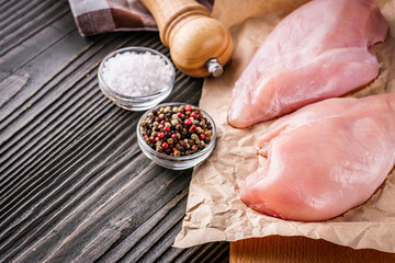 raw chicken fillet on a dark wooden rustic background