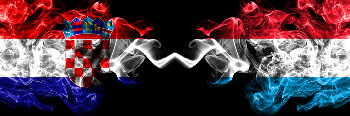 Croatia, Croatian vs Luxembourg smoky mystic flags placed side by side. Thick colored silky abstract smoke flags.