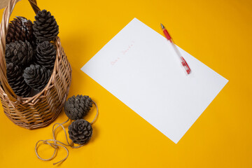 Children's letter to Santa for Christmas on yellow background with pine cones