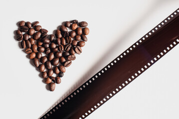 Una tira de película analógica de 35mm junto a granos de café formando un corazón