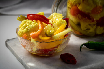 Pickled sauerkraut, pepper, celery, vegetables.  Jar with pickles,cauliflower, carrots, bell peppers, garlic and celery