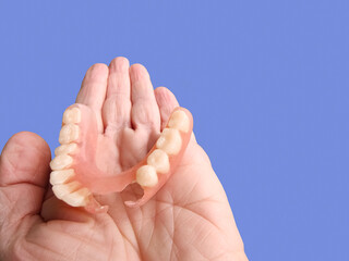 flexible nylon denture on female hand. Removable dentures flexible, devoid of nylon, hypoallergenic exempt from monomer