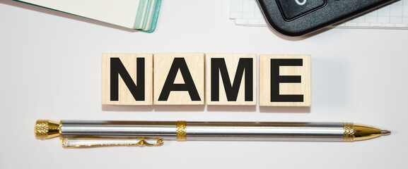 text name written on wooden cubes on top of a notebook and a pen on the bottom
