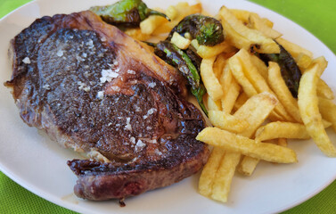 Beef entrecote with a garnish of fried potatoes and padron peppers, Spain
