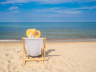 Woman relaxing on beach sitting on sunbed
