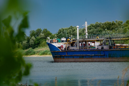 Navigable color barge floating on the river, carrying cargo in the Rostov region. Summer in nature on the don river and passing by, large and long ships made of painted metal