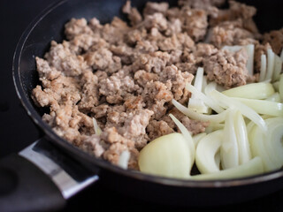 Pork steaks in frying pan with onion
