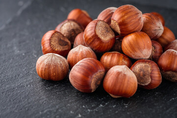 fresh natural hazelnuts on a dark stone background
