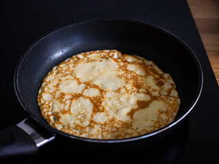 Sweet crepes frying in pan
