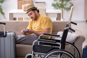 Young man in wheel-chair preparing for departure at home