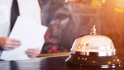 Hotel reception service bell with concierge holding files