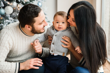 Young family near festive Christmas tree