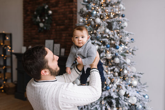 A young father and little son near Christmas tree