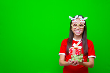 Obraz na płótnie Canvas A girl with dark hair in a red T-shirt and in funny glasses in her hands holds boxes of gifts for the Christmas holidays and New Year. 