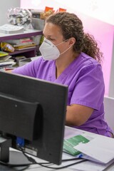 Masked nurse checking medical records