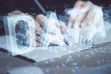 Double exposure of writing hands on background with data solution hologram on front. Technology concept. Close up