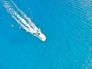 vista aerea vertical desde arriba de un barco a gran velocidad sobre las aguas saladas y azules de las playas de Quintana Roo