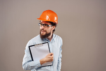 A man in orange paint with documents in hands building an industrial business