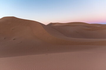 Fototapeta na wymiar Huge desert dunes of Erg Chigaga, at the gates of the Sahara, al amanecer. Morocco. Concept of travel and adventure.