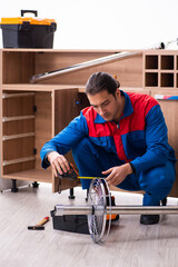 Young handsome male carpenter working indoors