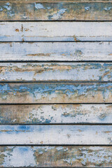 Full frame image of the weathered wooden wall with exfoliated light blue paint. Vertical texture of old painted wood. Wallpaper or background for mobile phone. Empty template for design, copy space