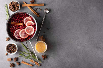 hot cranberry drink with lemon honey and spices in a gray saucepan