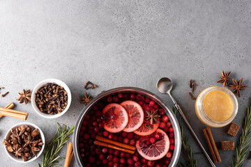 hot cranberry drink with lemon honey and spices in a gray saucepan