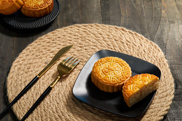 High angle shot of mooncakes on a plate with fork ad knife on a mat